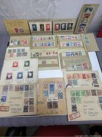Full view of the stamps and covers spread out on a flat surface, showing multiple sheets with vintage German stamps and addresses.