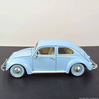 Side view of the baby blue 1955 Volkswagen Beetle 1:18 scale diecast model. Shows detailed design including wheels and body shape.