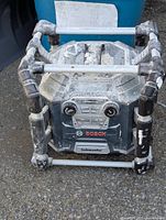 Front view showing Bosch PowerBoss radio and charger with control panel and subwoofer label, dirt and wear visible on frame.