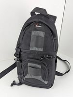 Front and side view of the black Lowepro camera backpack.