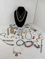 Full view of all jewelry pieces arranged around a black display bust, showing variety and quantity.