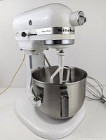 Tilt-head front angle view showing mixer body, bowl, paddle attachment.