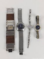 Photo of four watches with different styles and bands including leather and metal, arranged from left to right.