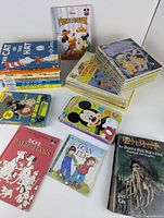 Photo showing multiple children's books including Dr. Seuss's The Cat in the Hat series, Disney's Prince & Pauper, 101 Dalmatians, and Pirates of the Caribbean.