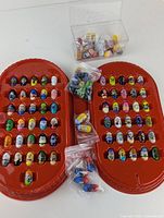 Full view of Mighty Beanz collection spread in red plastic case, including loose Beanz in plastic bags and clear container