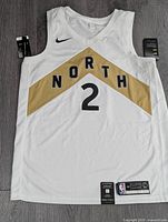 Front view of white jersey with gold “NORTH” chevron, black #2 and Nike Swoosh, tags attached.