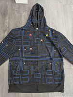 Full view of the men's zipped hoodie showing Pac-Man maze print with various characters and game elements.