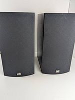 Pair of black PSB Image 2B bookshelf speakers shown standing next to each other with front facing forward.