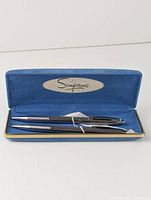 Front view of vintage pen and pencil neatly placed inside blue velvet-lined Simpsons case showing condition and branding.