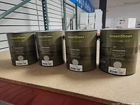 Four 1-gallon cans of GreenSheen Eco-Friendly Paint in Dove color on a shelf.