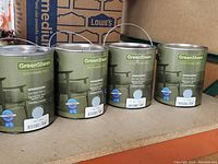 Photo showing four 1-gallon cans of GreenSheen Eco-Friendly Paint on shelf.
