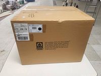 Photo showing the sealed original packaging of the light fixture box with shipping labels and Fair Trade Certified logo.