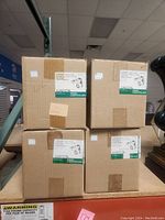 Four cardboard boxes stacked two by two, each box labeled with Lytespan Lightolier branding and track lighting product details.