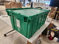 Side view of green plastic tote showing rectangular shape, reinforced walls, and interlocking lid edges.