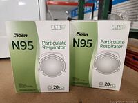 Front view of two opened boxes of Niosh N95 particulate respirator masks, each labeled 20 pieces, showing product packaging and branding.