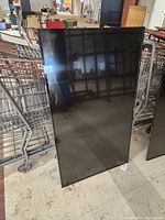 Front view of the large 55-inch NEC E556 display monitor panel leaning against a cart.