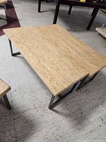 Top perspective of one bench showing the rectangular stone top and metal legs.