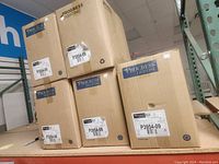 Stacked boxed Progress Lighting fixtures labeled P3954-09.