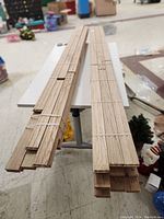 Two bundles of unfinished solid red oak hardwood flooring planks stacked and secured with ties.