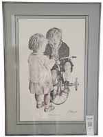 Full view of framed black and white artwork titled 'A Precious Moment' showing two children, one on a tricycle, set on a light-colored wall.
