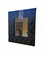 Front view of the folk painted mirror showing blue and yellow floral and swirl patterns on the wooden frame around a central square mirror.