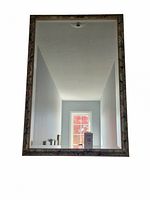 Front-facing photo of the rectangular framed mirror showing its clear reflective surface and decorative frame.