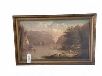 Framed landscape oil painting showing lake with boats, trees, and mountains
