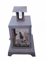 Front view of the metal outdoor fireplace showing mesh door with firewood inside and chimney cap on top.