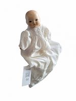 Front view of the handmade vintage porcelain doll wearing a white antique lace dress, showing facial features and dress details.