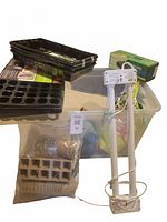 Photo showing all included seed sprouting items including grow lights, starter trays, peat pots, heat mat box, and storage bin
