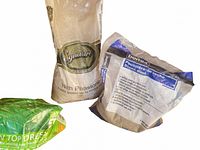 Two bags of fine stones, one partially used stone dust and one unopened pea-stone bag with printed labels.