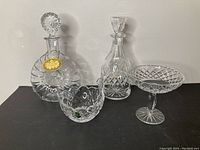 Full lot view showing two decanters and two bowls in clear cut crystal with labels.
