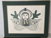 Image of the framed print showing the figure with two owls on each side, green matte and beige borders visible