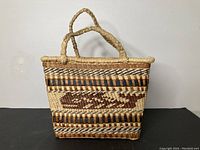 Front view showing whale motif and braided handles