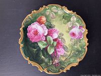 Full view of the vintage hand painted floral ceramic charger with ornate gold edging.