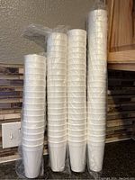 Photo of four sleeves of white disposable foam cups, each sleeve containing multiple cups stacked and shrink-wrapped.
