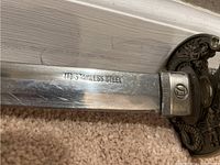 Blade portion showing '440 Stainless Steel' stamping and visible wear and scratches.