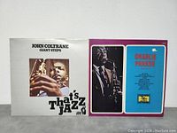 Front album covers of John Coltrane 'Giant Steps' and Charlie Parker 'Volume V' vinyl records showing artist photos and album titles.