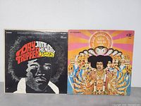 Front covers of the two vinyl record albums: 'Day Tripper' and 'Axis: Bold as Love' showing artist names and cover art.