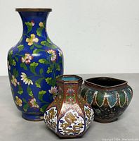 Front view showing all three cloisonné pieces - tall blue vase, hexagonal dragon vase, round floral bowl
