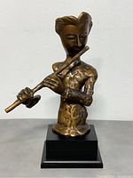 Front view of bronze flutist sculpture, showing figure playing the flute mounted on black base