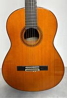 Front view of guitar body showing spruce top, bridge and soundhole rosette