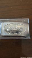 Front view of the silver bar showing the Mercer Raceabout 1916 vintage car design and purity marking in protective sleeve.