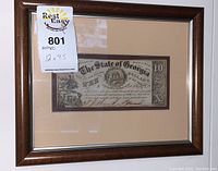 Front view of framed note with auction tag showing overall condition and framing