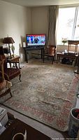 Full room view showing the rug laid out beneath seating and a TV
