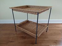 Photo of the full folding coffee/service tray table with woven rope trays and black steel frame on hardwood floor.
