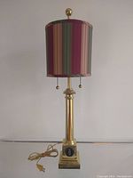 Full view of the vintage brass table lamp with dual pull chains and striped lampshade.