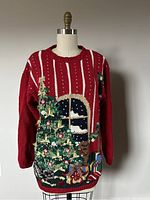 Full front view of the red hand knit Christmas sweater showing tree, presents, and winter window scene