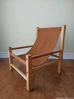 Front and side view of kids sling chair showing orange-brown canvas seat and natural wood frame with bolts