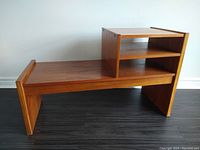Full side view of vintage teak media stand showing stepped open shelves and smooth wood grain.